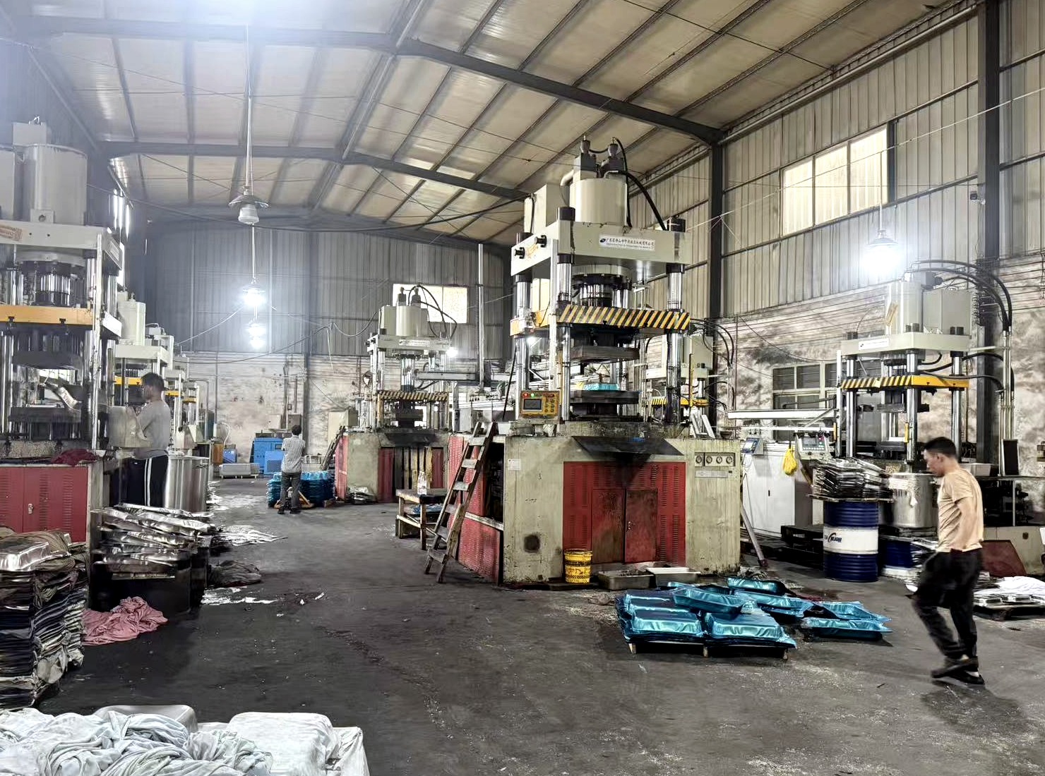 Hydraulic forming presses and metal parts inside a production workshop