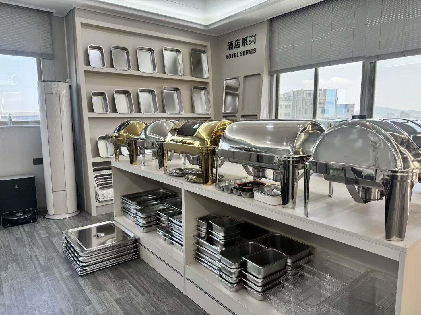 Stainless-steel food pans and buffet serving dishes displayed in a product showroom