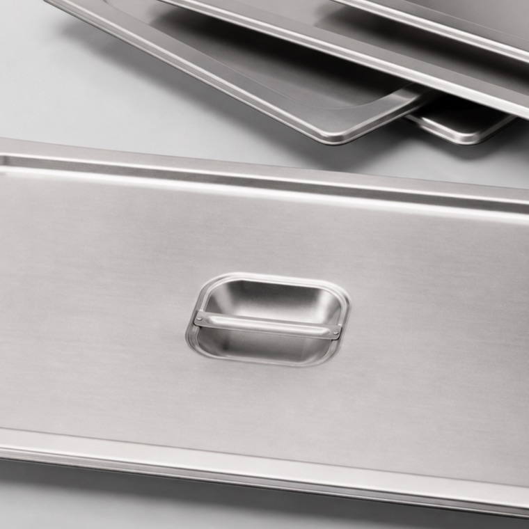 Close view of stainless-steel food pans and matching lids