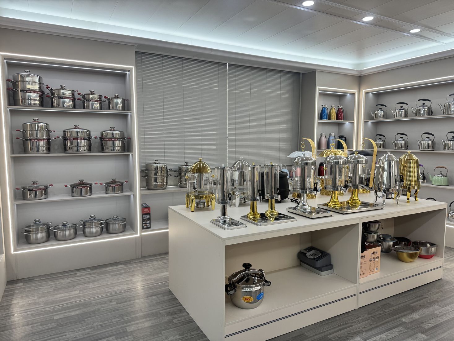 Buffet dispensers, kettles and stainless-steel serving ware displayed in a showroom